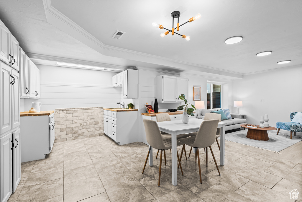 Dining room with crown molding and a chandelier