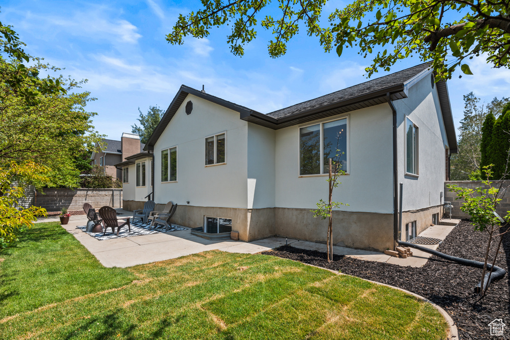 Back of property with a patio and stucco siding