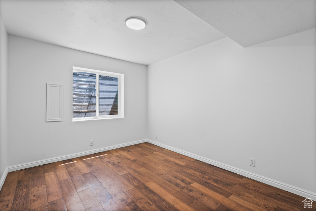 Unfurnished room with dark wood finished floors and baseboards