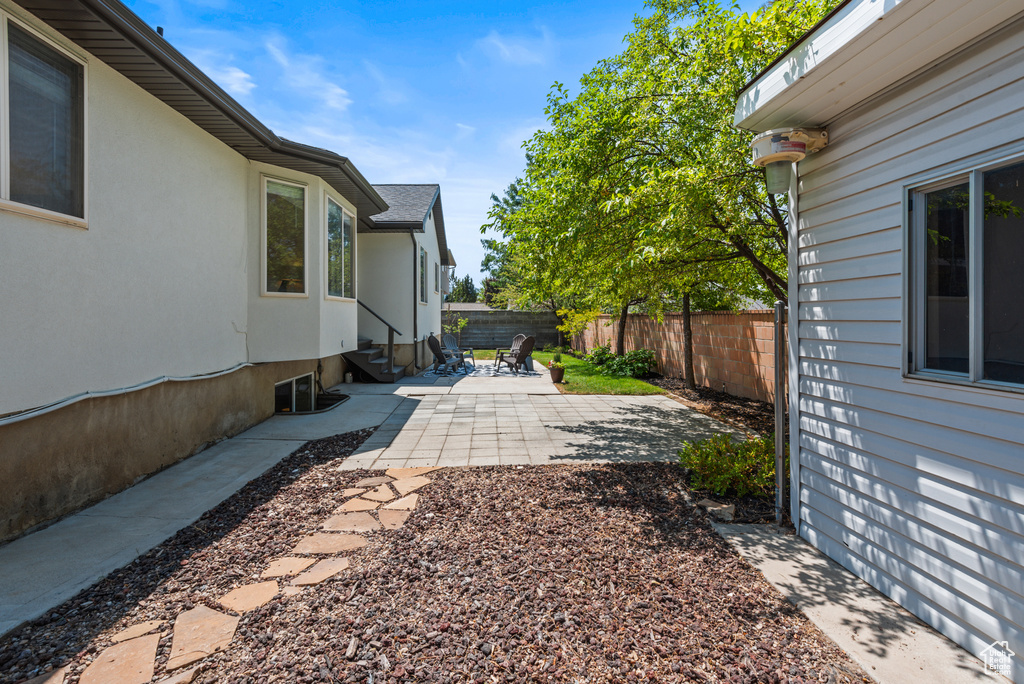 Fenced backyard with entry steps and a patio area