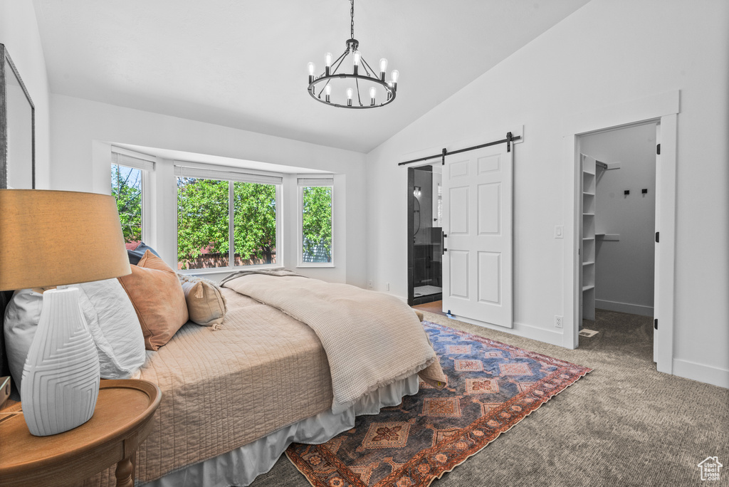 Bedroom with a barn door, a chandelier, carpet, lofted ceiling, and a spacious closet