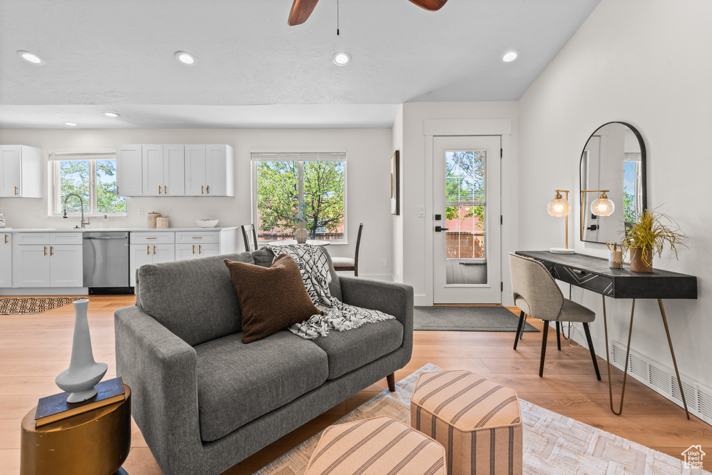 Living room with a ceiling fan, recessed lighting, and light wood-style flooring