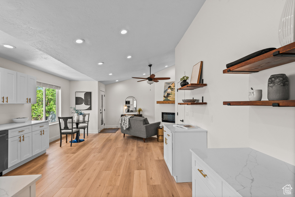 Kitchen featuring a glass covered fireplace, recessed lighting, light wood-type flooring, a ceiling fan, and open shelves