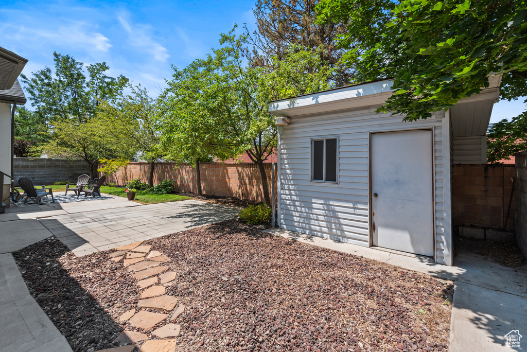 Fenced backyard with a patio and a storage shed