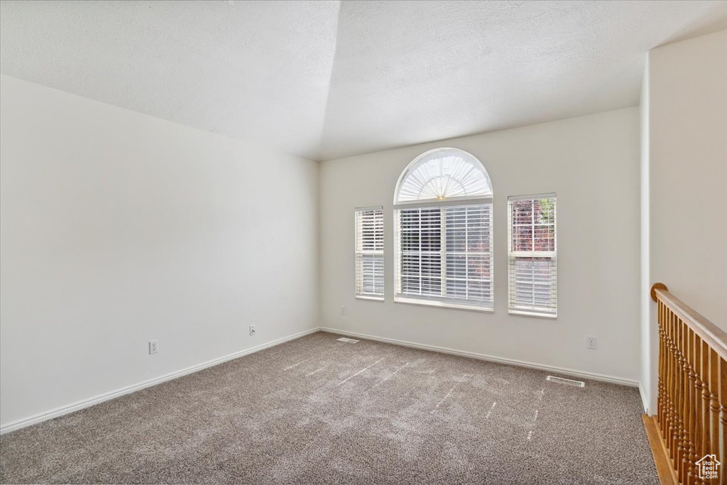 Carpeted empty room featuring baseboards
