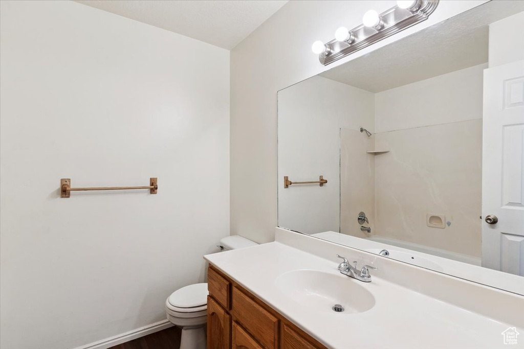 Full bathroom with vanity, wood finished floors, and washtub / shower combination