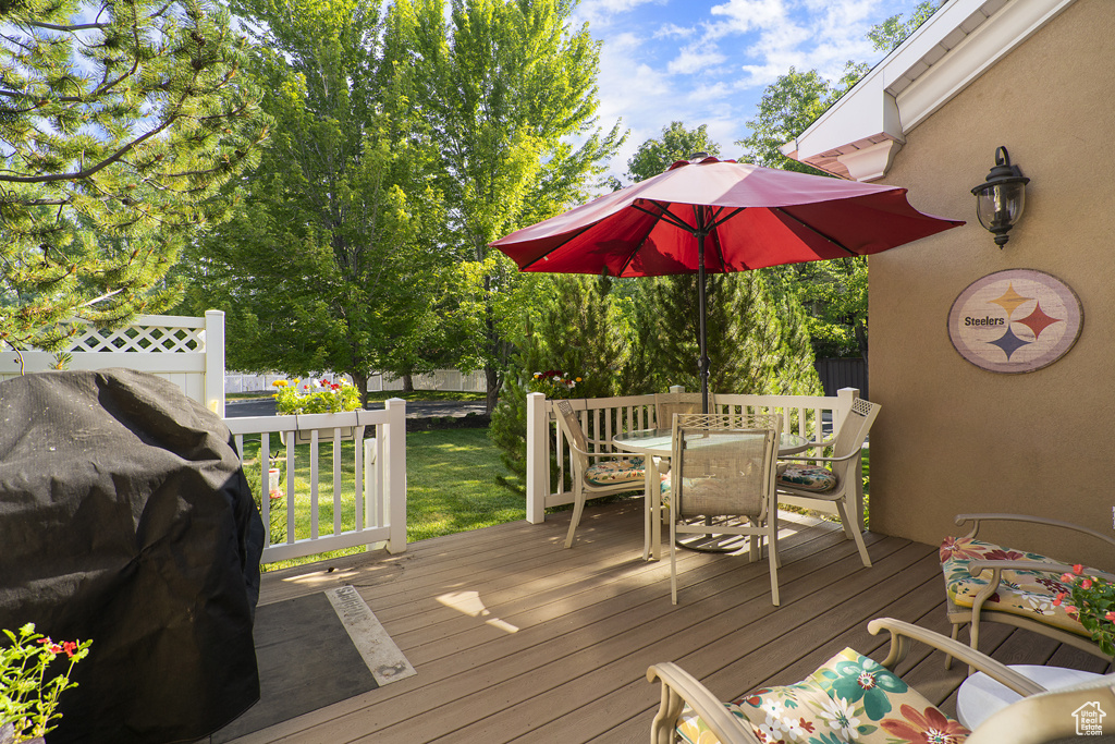 Wooden deck featuring outdoor dining area and grilling area