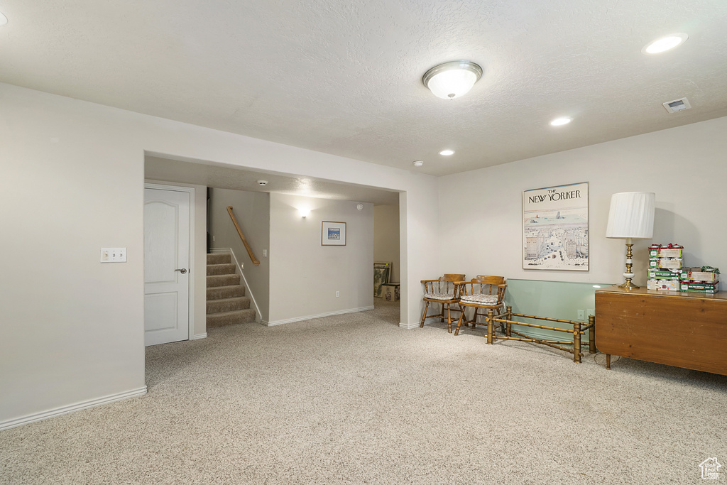 Sitting room with carpet floors, stairs, and recessed lighting