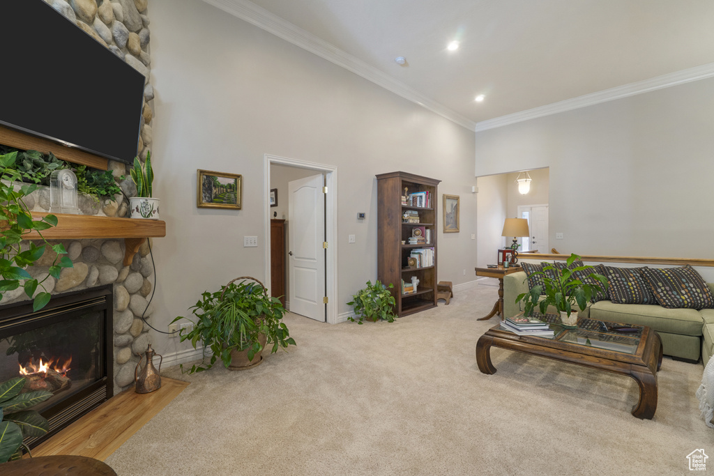 Living area featuring crown molding, a high ceiling, a fireplace, carpet flooring, and recessed lighting