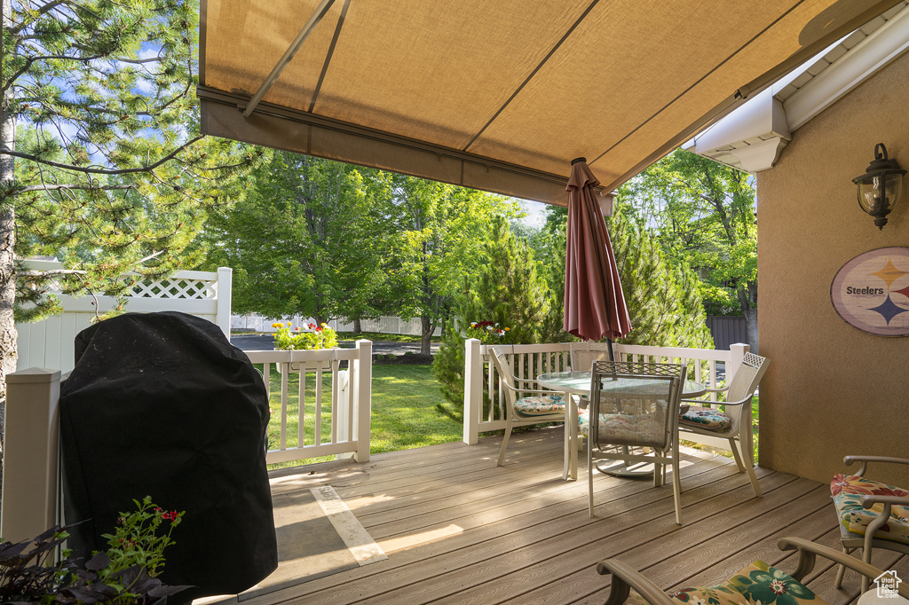Wooden deck featuring area for grilling and outdoor dining area