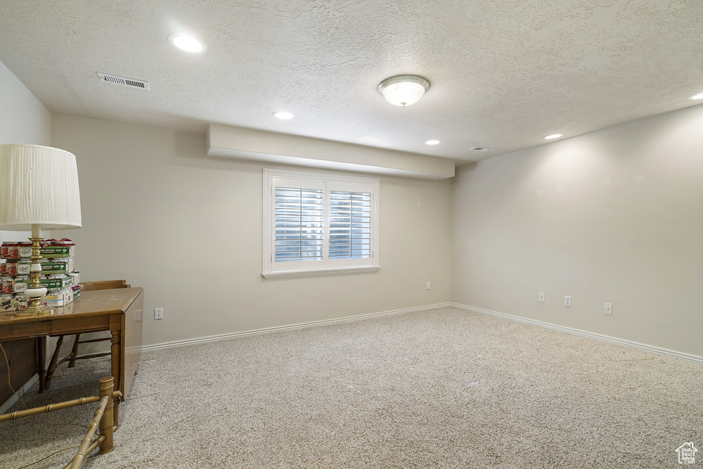 Basement featuring a textured ceiling, recessed lighting, and carpet flooring