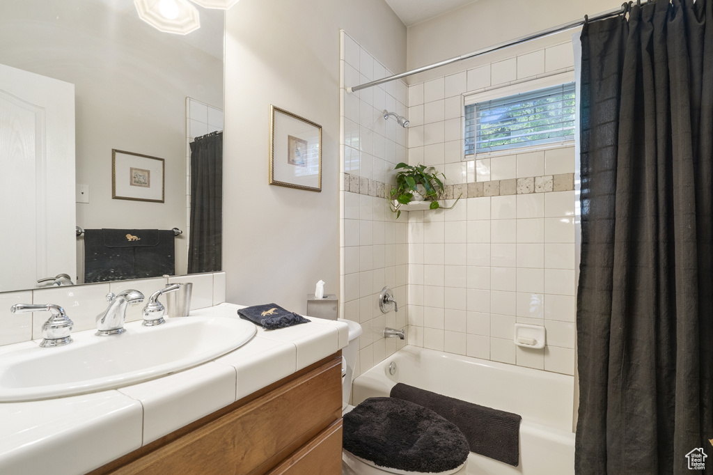 Bathroom with shower / bath combo with shower curtain and vanity