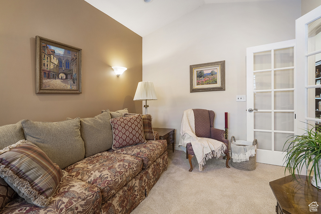 Carpeted living area with lofted ceiling