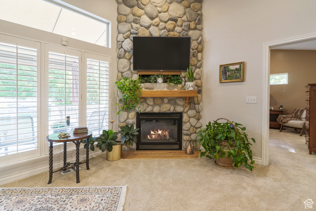 Carpeted living room with a fireplace and baseboards