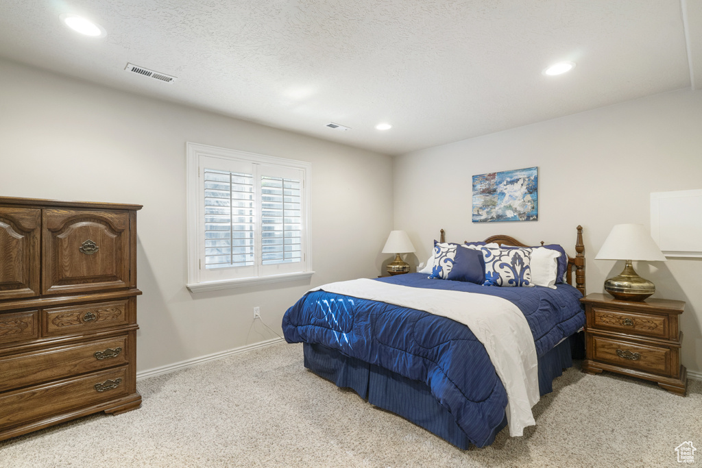 Bedroom with light carpet and recessed lighting