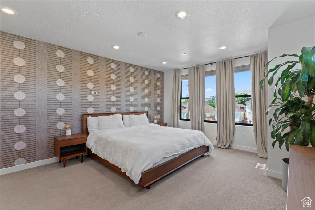 Bedroom with recessed lighting, carpet floors, a textured ceiling, and wallpapered walls