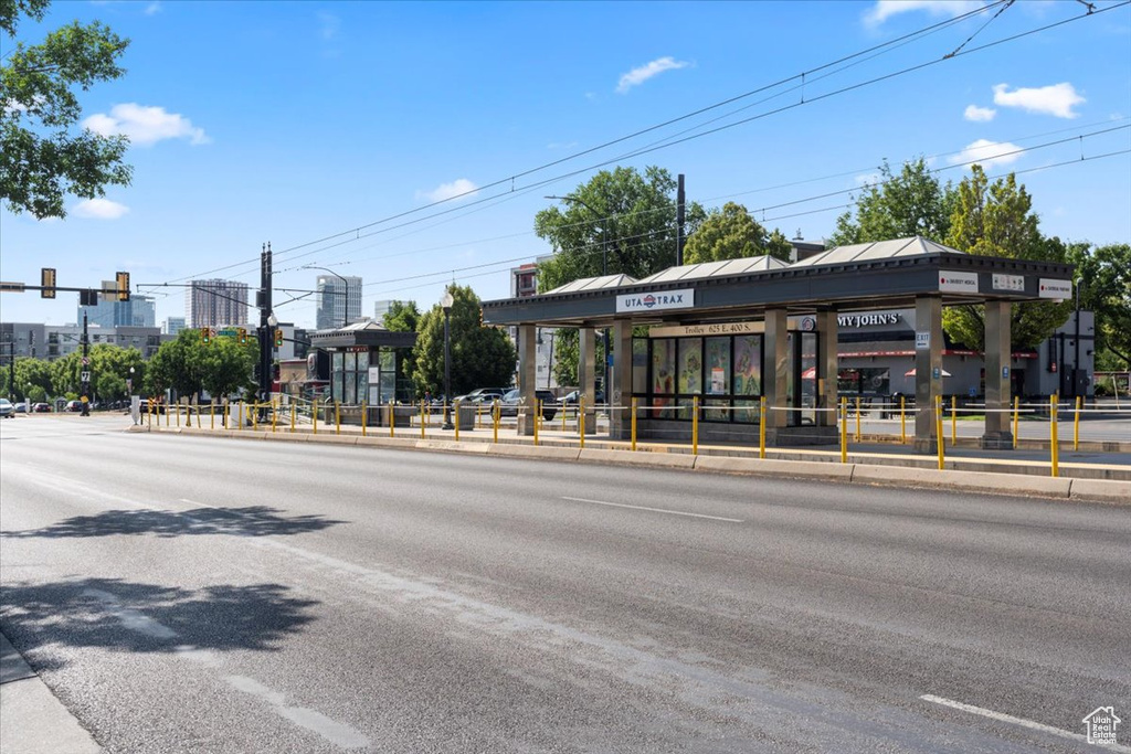 View of asphalt street with street lights, curbs, traffic lights, and sidewalks