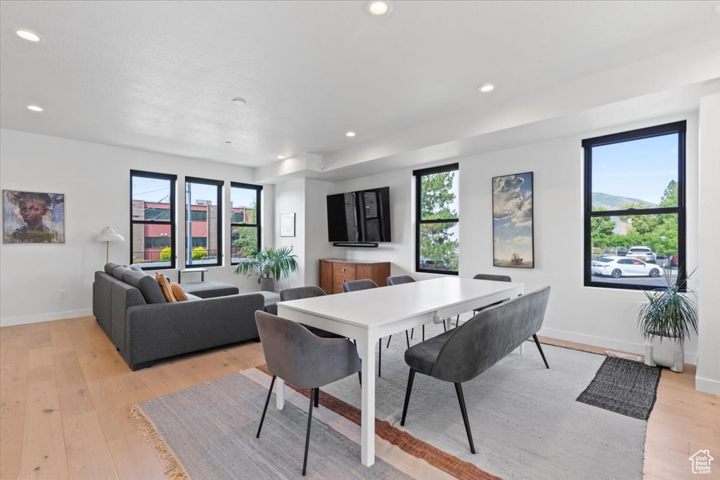 Dining space with healthy amount of natural light, recessed lighting, and light wood-style floors