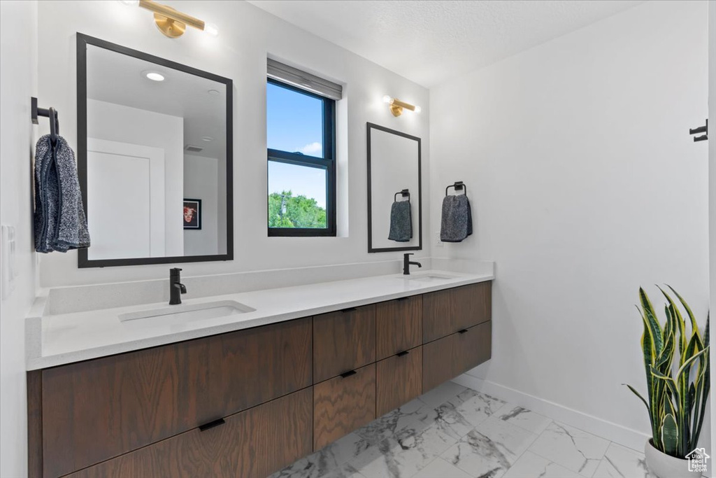 Full bathroom with double vanity and marble look tile flooring