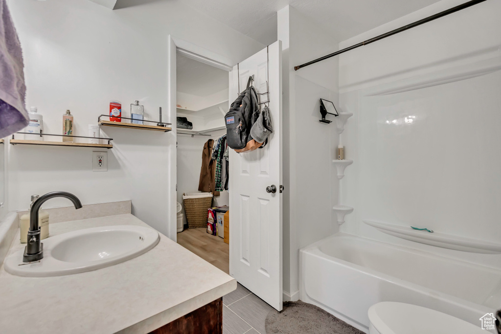 Bathroom featuring vanity, shower / bathtub combination, tile patterned flooring, and a spacious closet