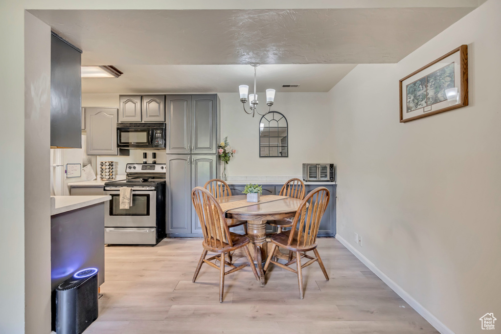 Dining space with light wood-style floors and a chandelier