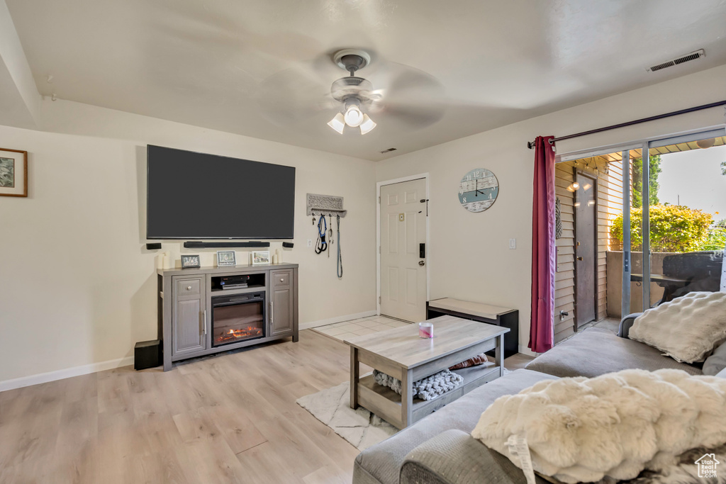 Living room with ceiling fan and light wood-type flooring