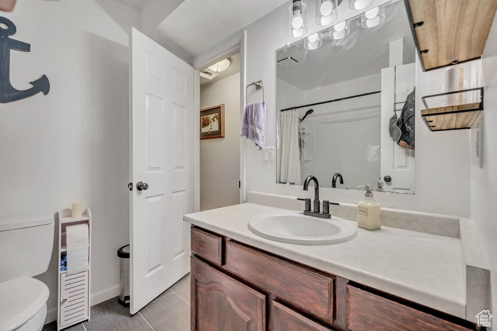 Bathroom featuring vanity, a shower with shower curtain, and tile patterned flooring