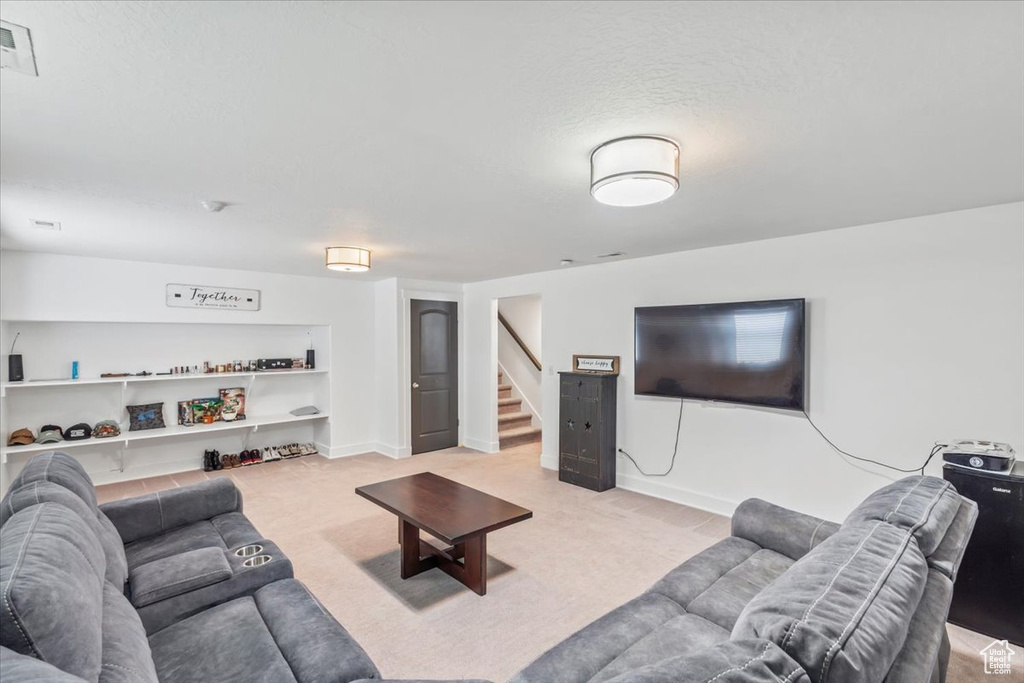 Carpeted living area with stairs and a textured ceiling