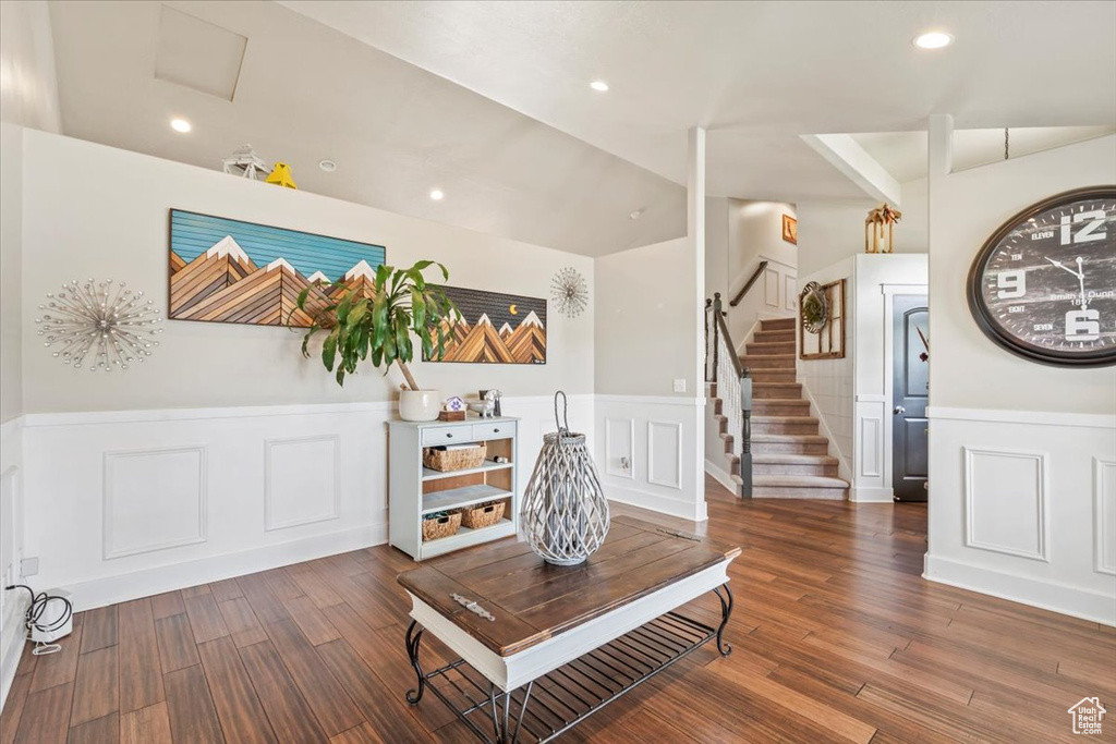 Living area with a wainscoted wall, a decorative wall, wood finished floors, stairs, and recessed lighting
