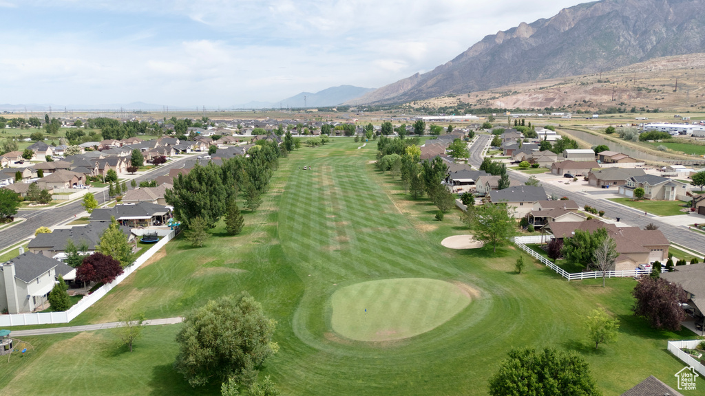 View of property location featuring nearby suburban area, a mountainous background, and a golf course