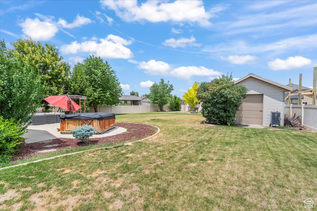 Fenced backyard with a hot tub