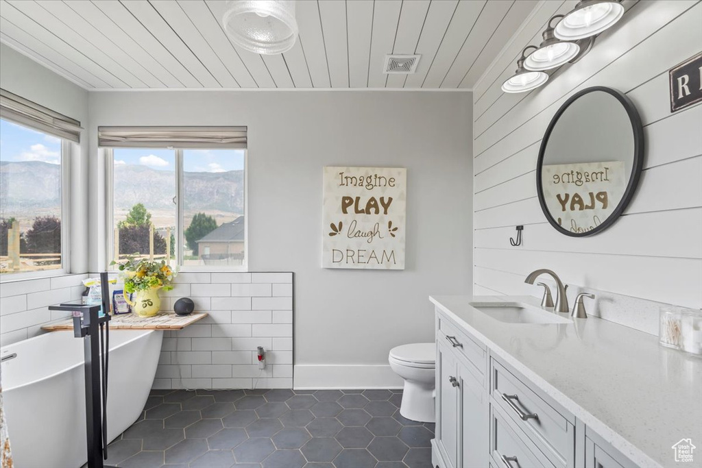 Bathroom featuring a soaking tub, vanity, a mountain view, tile patterned flooring, and wooden ceiling