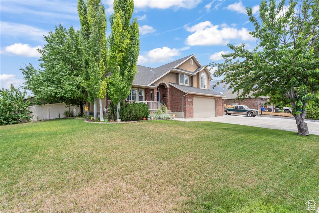 View of front of property featuring brick siding, driveway, and a garage