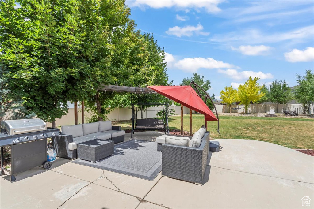 Fenced backyard featuring an outdoor hangout area, a grill, and a patio