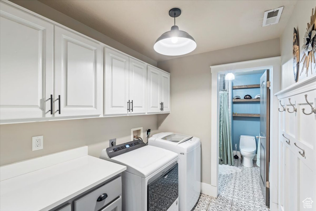 Laundry area featuring cabinet space and washer and dryer