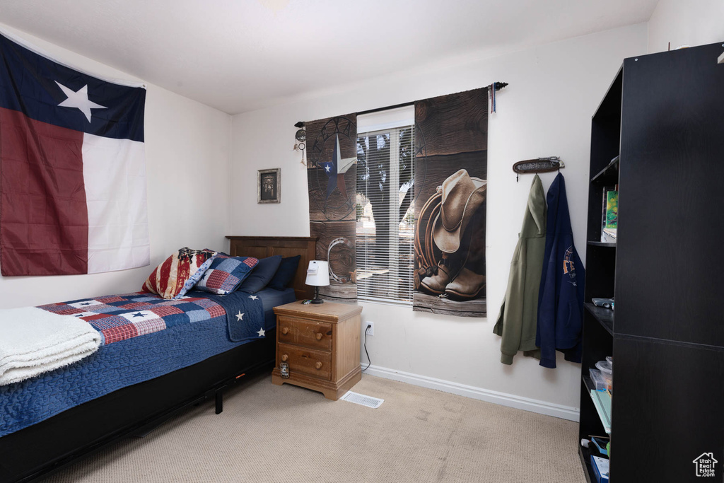 Bedroom featuring carpet floors and baseboards