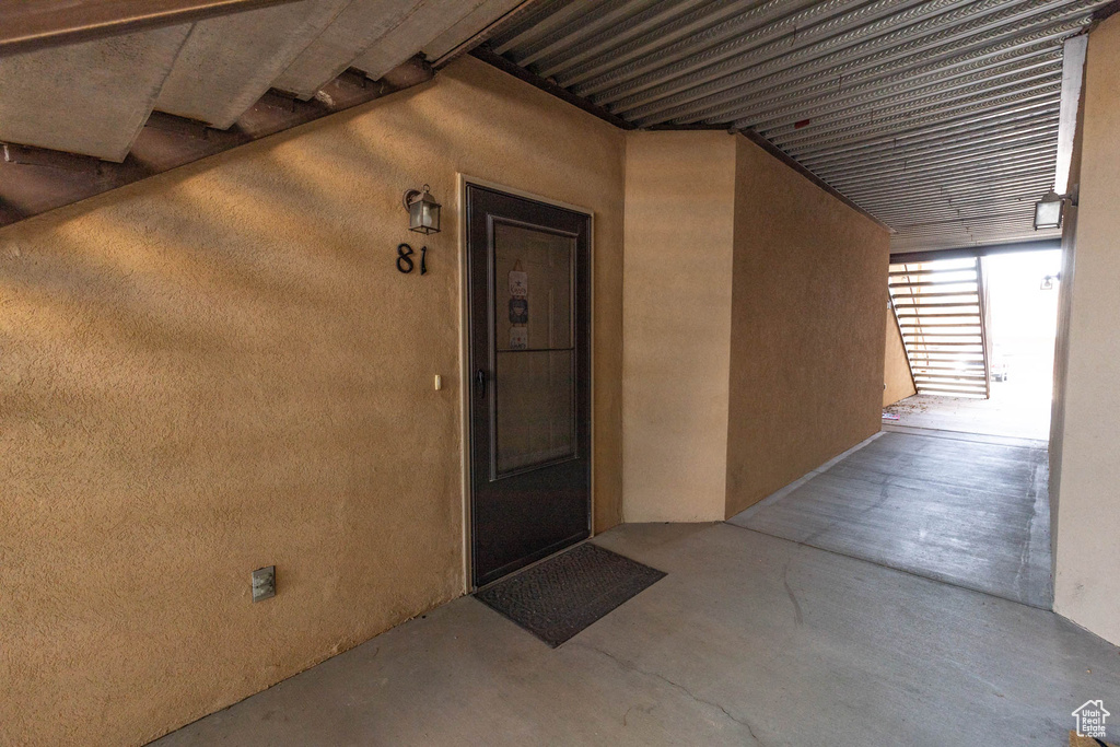 Entrance to property with stucco siding and a patio area