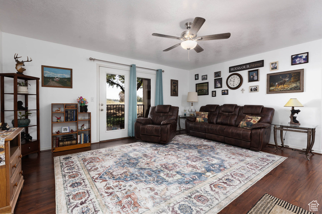 Living room with a ceiling fan and dark wood-style flooring