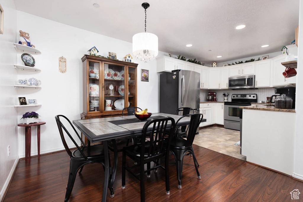 Dining space with a chandelier, dark wood-style flooring, and recessed lighting