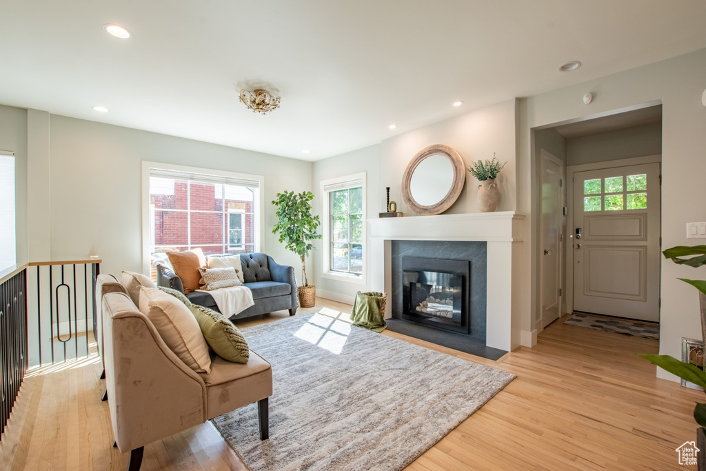Living room with light wood finished floors, plenty of natural light, recessed lighting, and a fireplace