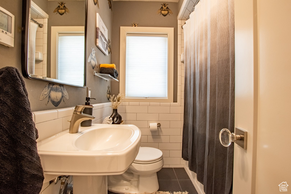 Bathroom featuring tile patterned flooring and tile walls