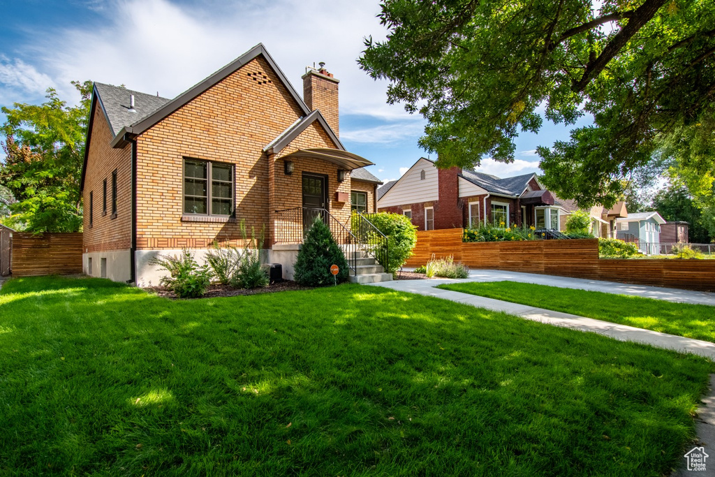 View of front of home featuring a chimney and brick siding