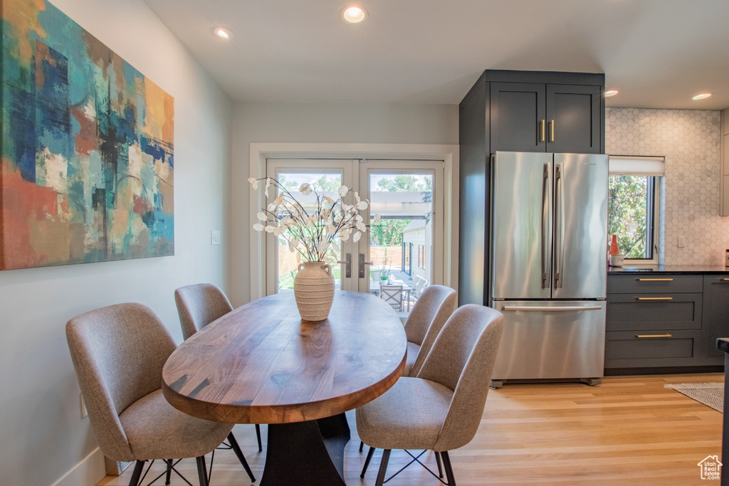 Dining space with healthy amount of natural light, light wood finished floors, french doors, and recessed lighting