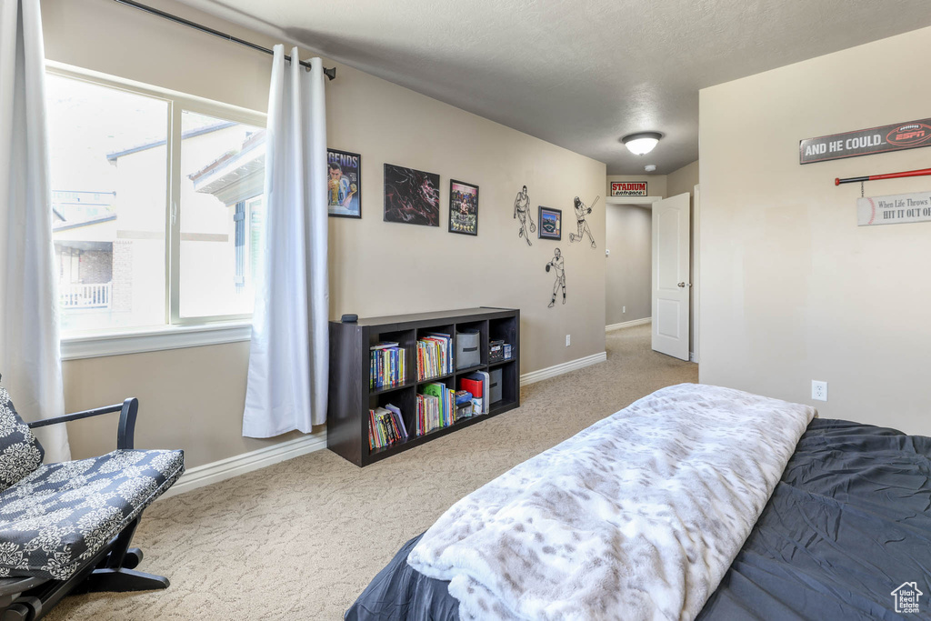 Bedroom featuring carpet and baseboards