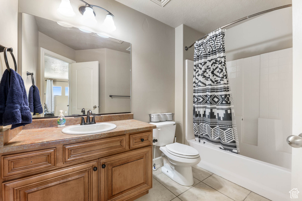 Bathroom with vanity, shower / bath combo with shower curtain, and tile patterned floors