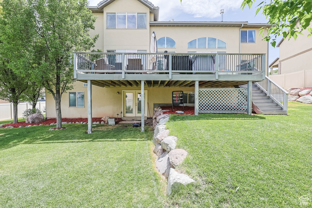 Back of property with stucco siding and a wooden deck