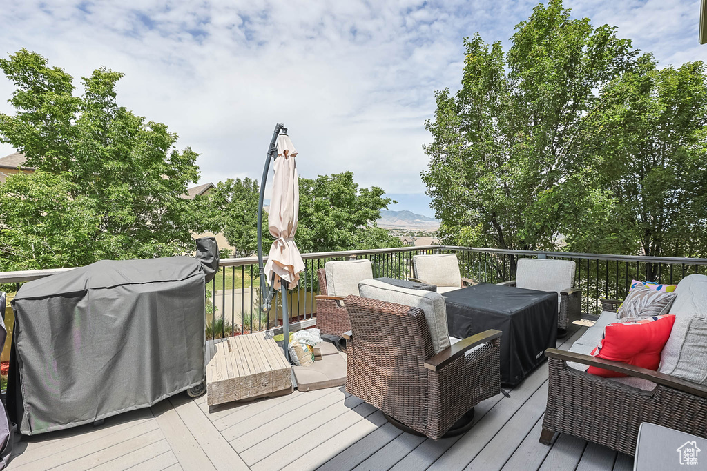 Wooden deck featuring an outdoor hangout area, a mountain view, and area for grilling