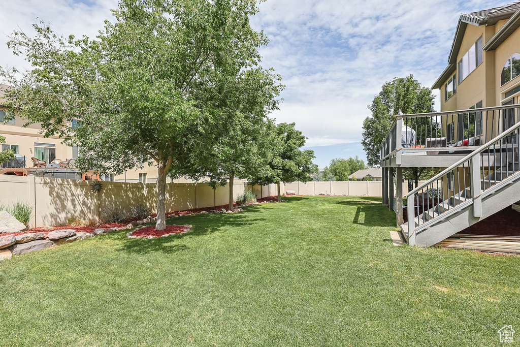 Fenced backyard with stairway and a deck