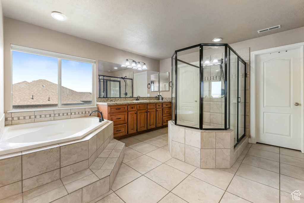Full bathroom featuring vanity, a garden tub, a stall shower, and tile patterned flooring