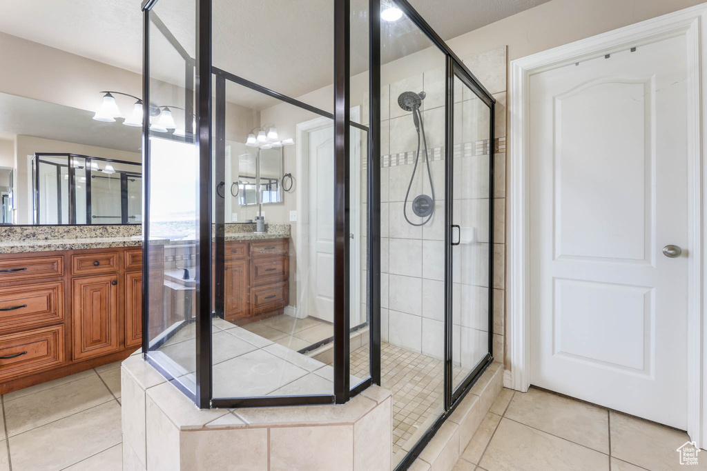 Full bathroom with a stall shower, vanity, and tile patterned floors